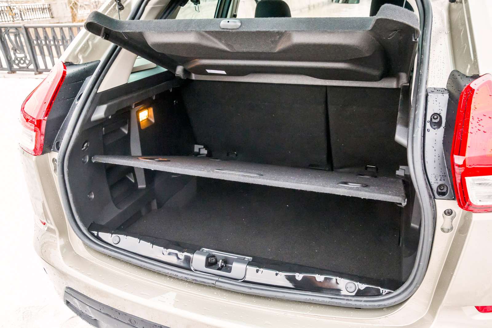 Lada XRAY. Багажник радует правильной формой и приличным объемом. Дверь отпирается не кнопкой, как на «французах», а клавишей между лампами подсветки номера.